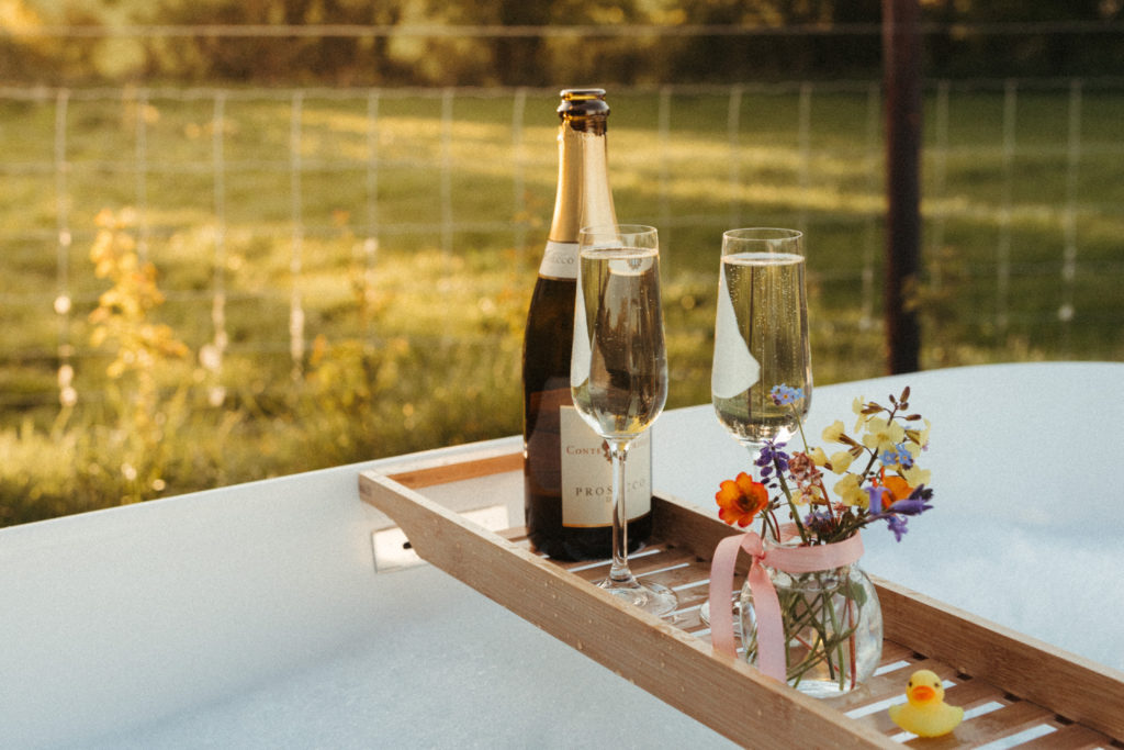 trelan farm glamping wales, outdoor tub with champagne
