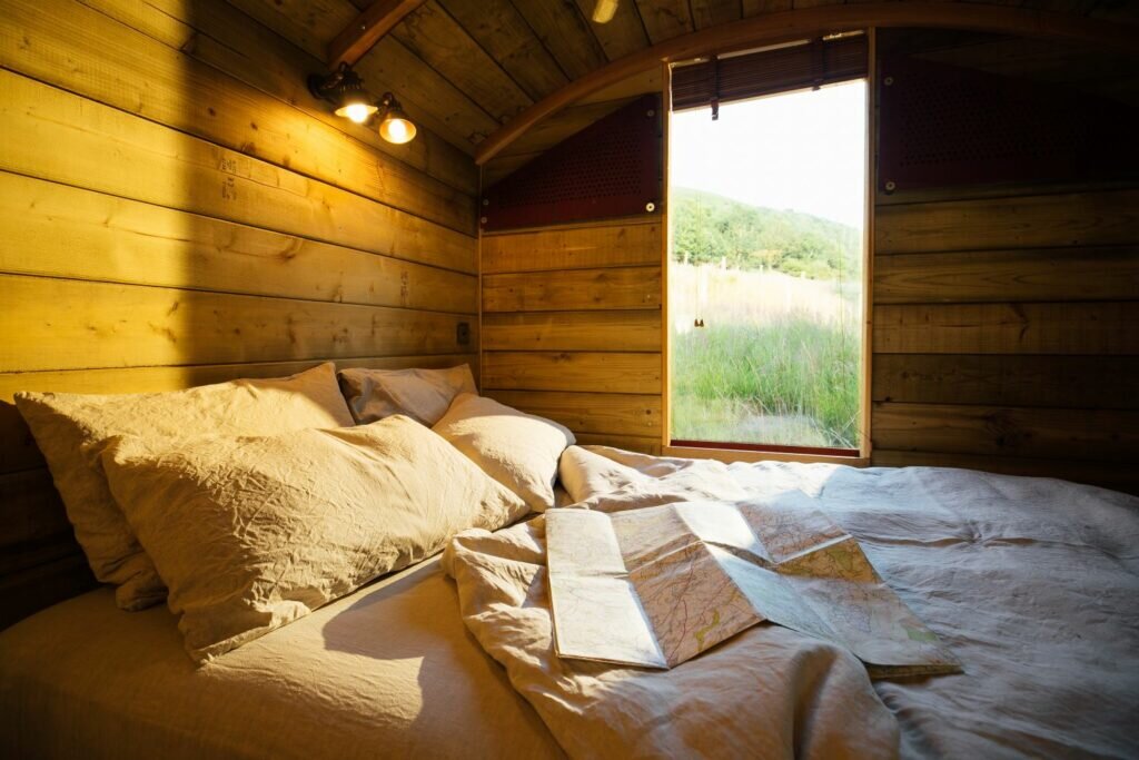 Doube bed with white sheets overlooking rolling fields