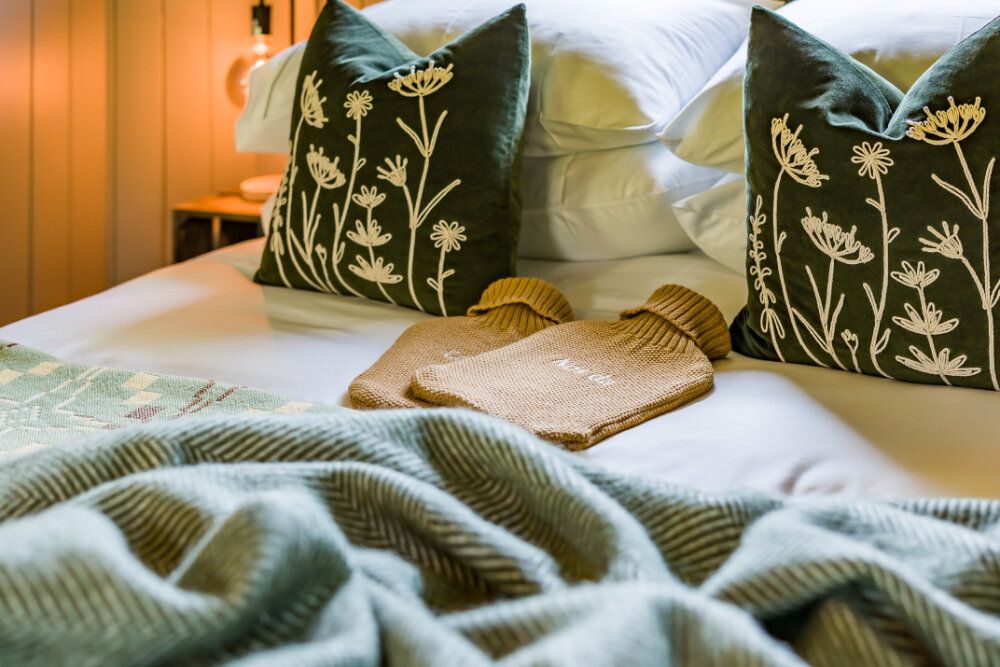 log cabins Carmarthenshire: Erwain Escapes - hot water bottles on bed