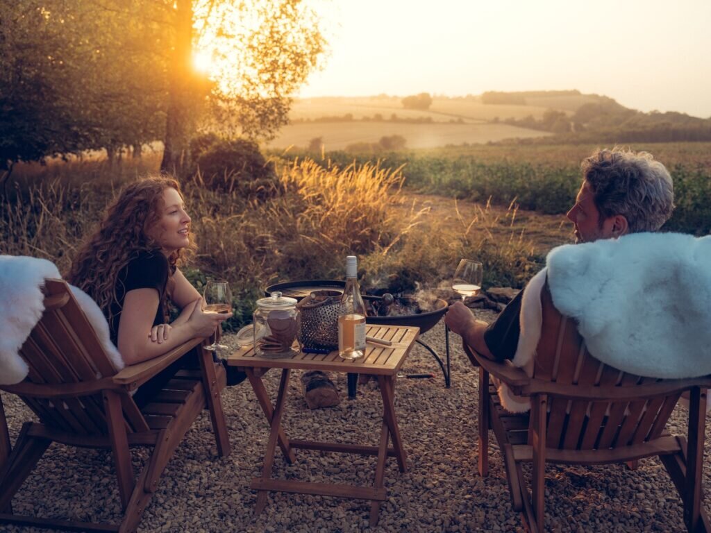 couple by firepit at the nook glamping cheltenham